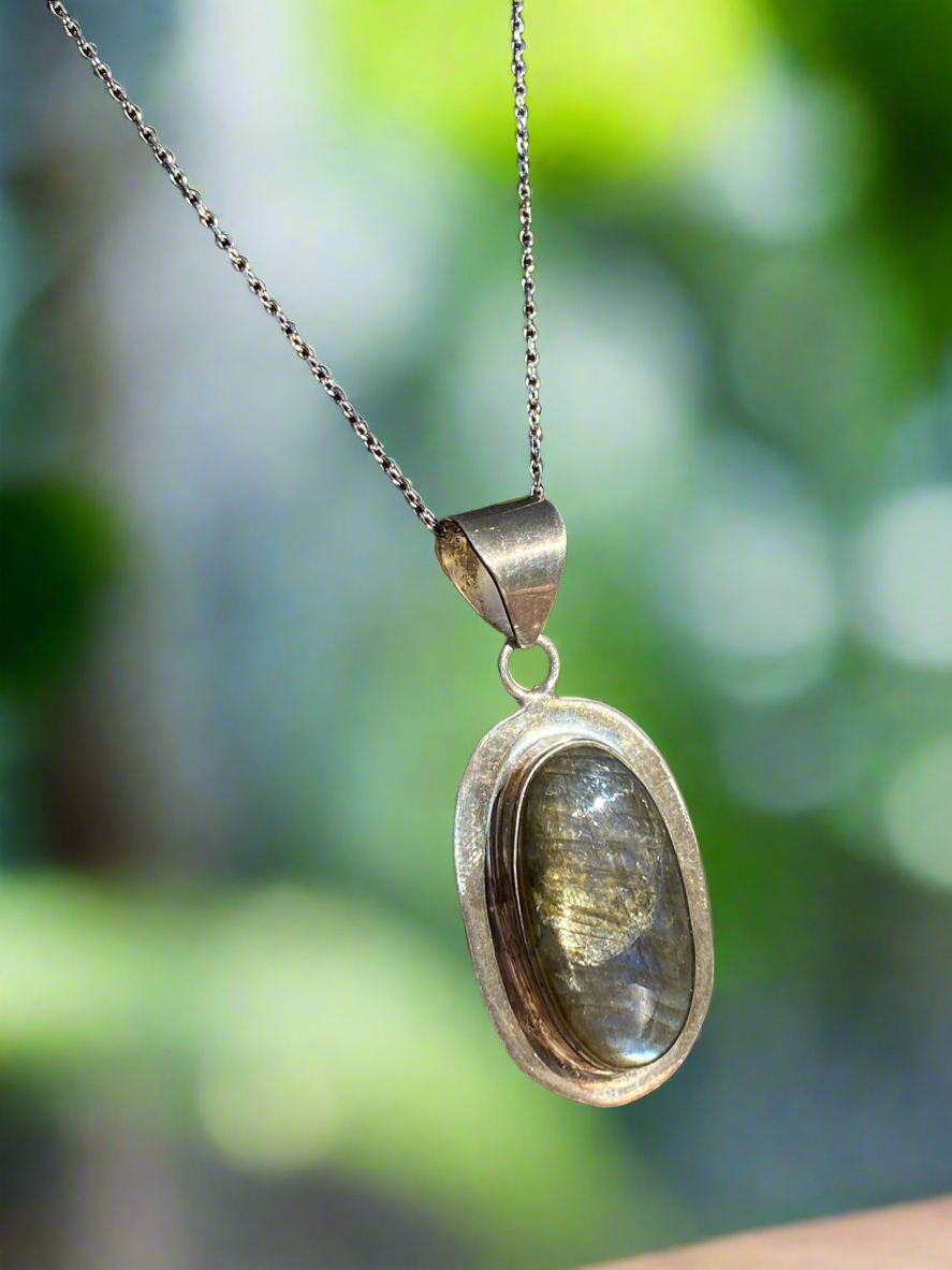 Labradorite crystal pendant, handcrafted labradorite necklace, oval labradorite charm, mystical labradorite jewelry, gemstone energy pendant, iridescent labradorite stone, spiritual crystal necklace, healing labradorite pendant, metaphysical labradorite jewelry, protective stone necklace, chakra-balancing jewelry, unique gemstone pendant, shimmering labradorite necklace, Labradorite pendant for transformation, holistic crystal jewelry