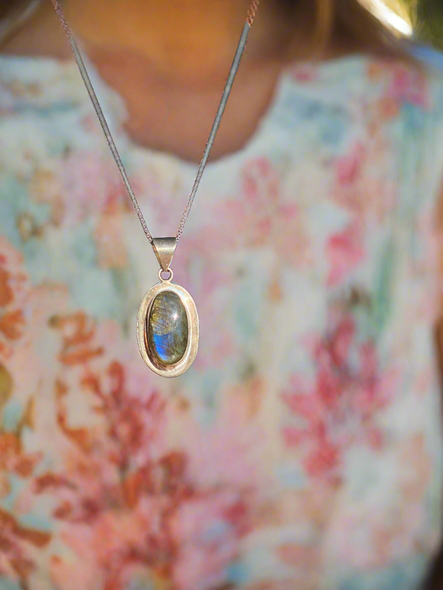 Labradorite crystal pendant, handcrafted labradorite necklace, oval labradorite charm, mystical labradorite jewelry, gemstone energy pendant, iridescent labradorite stone, spiritual crystal necklace, healing labradorite pendant, metaphysical labradorite jewelry, protective stone necklace, chakra-balancing jewelry, unique gemstone pendant, shimmering labradorite necklace, Labradorite pendant for transformation, holistic crystal jewelry